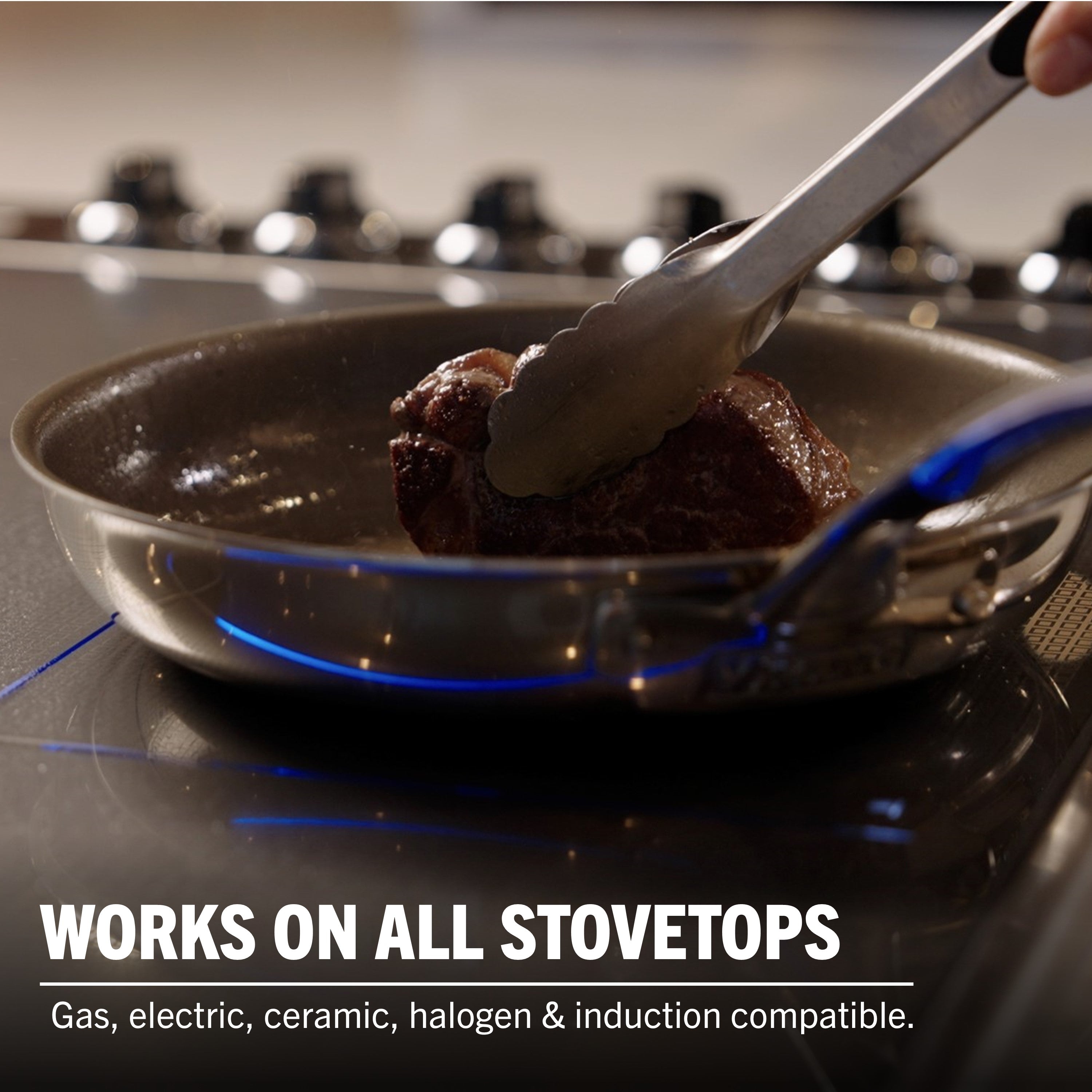 A hand sears meat with tongs in a Viking PureGlide Pro 3-Ply Fry Pan from Viking Culinary Products. Works on all stovetops—gas, electric, ceramic, halogen & induction—making it perfect for healthy cooking. Set includes 9.5" and 11" pans.
