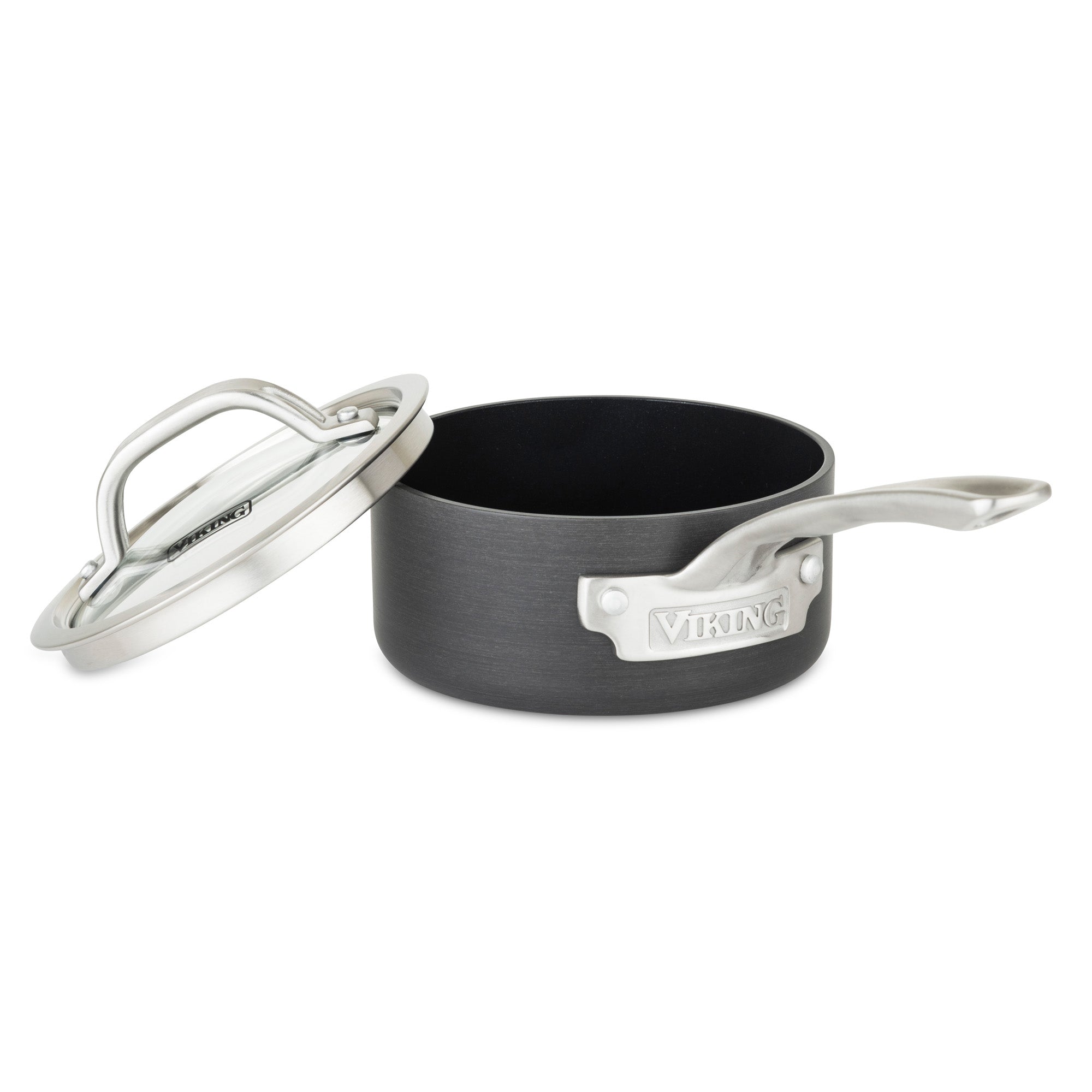 The Viking Culinary Products Hard Anodized Nonstick 1-Quart Sauce Pan features a black aluminum body, long silver stay-cool handle with branded metal badge, and a matching glass lid slightly tilted beside the pan.