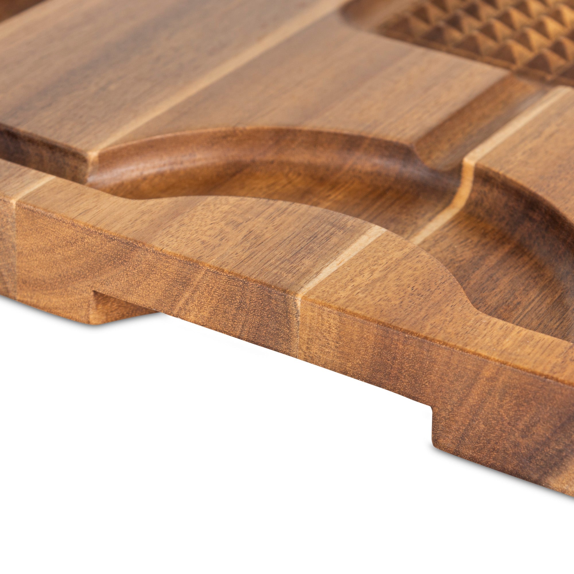 Close-up of the Viking Acacia Wood Cutting Board by Viking Culinary Products, featuring grooved sections, a smooth rounded edge, and accompanied by a 3-piece stainless steel carving set on a white background.