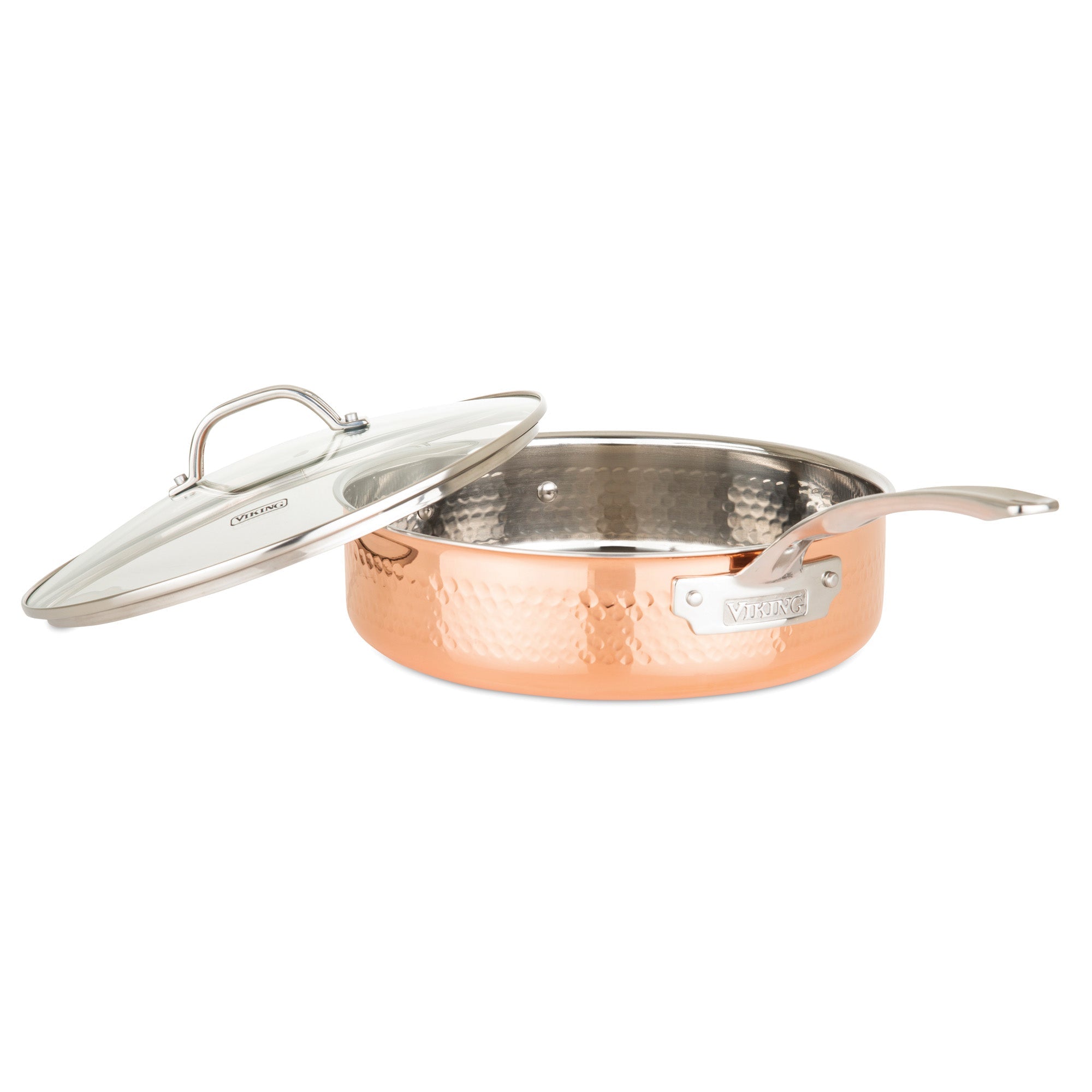 The Viking 3-Ply Hammered Copper Clad Sauté Pan by Viking Culinary Products features a long handle, glass lid, and shiny stainless steel interior, shown partially open on a white background.
