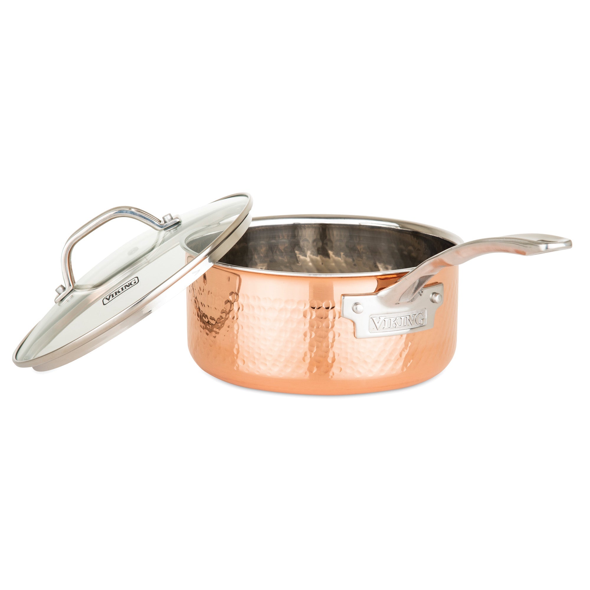 The Viking 3-Ply Hammered Copper Clad Cookware from Viking Culinary Products is showcased with its glass lid slightly lifted to display the polished interior, highlighting the set’s signature copper and stainless steel design on a white background.