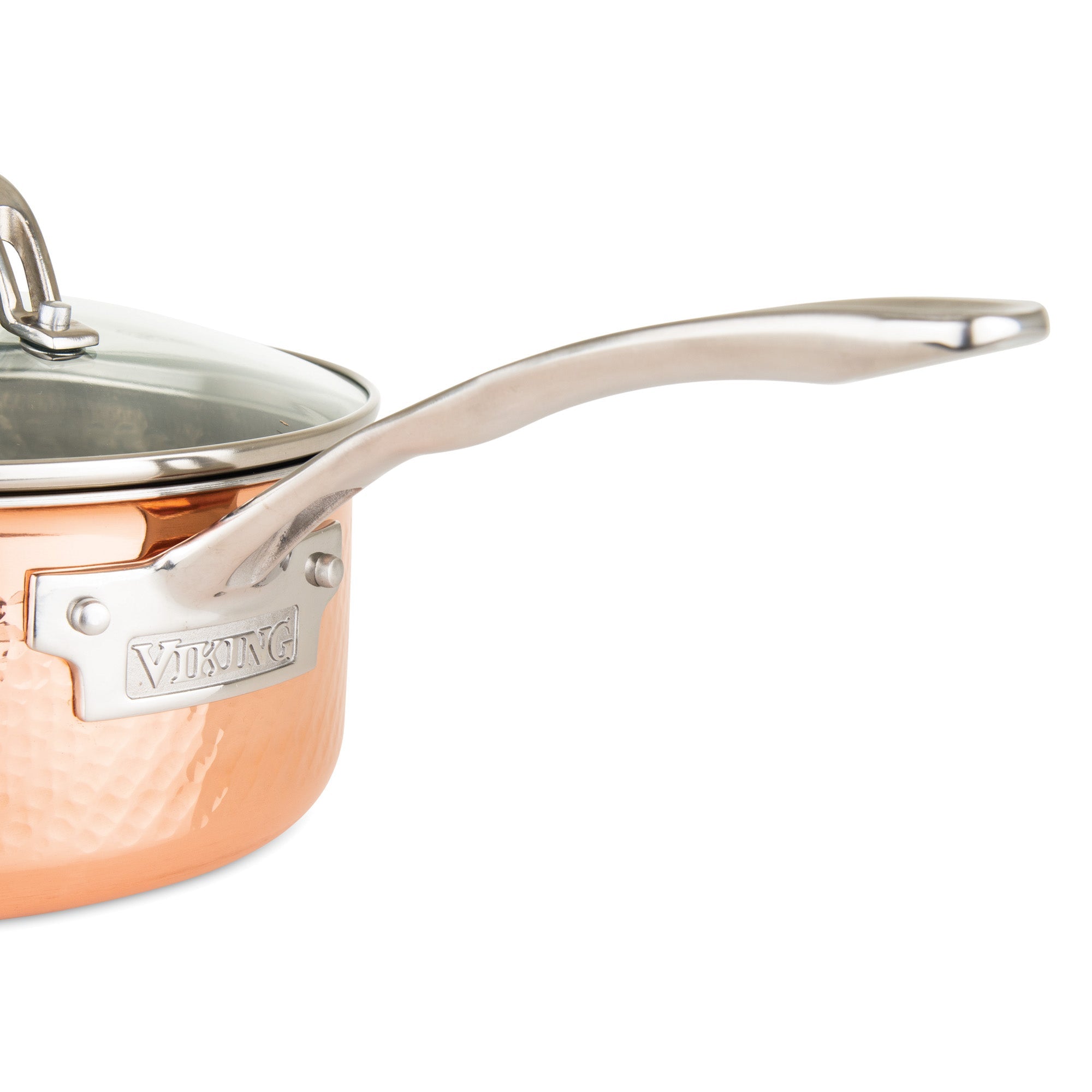 Close-up of a Viking 3-Ply Hammered Copper Clad saucepan from Viking Culinary Products 10-piece cookware set, highlighting its hammered copper finish, glass lid with metal rim, long curved handle, and stainless steel interior.