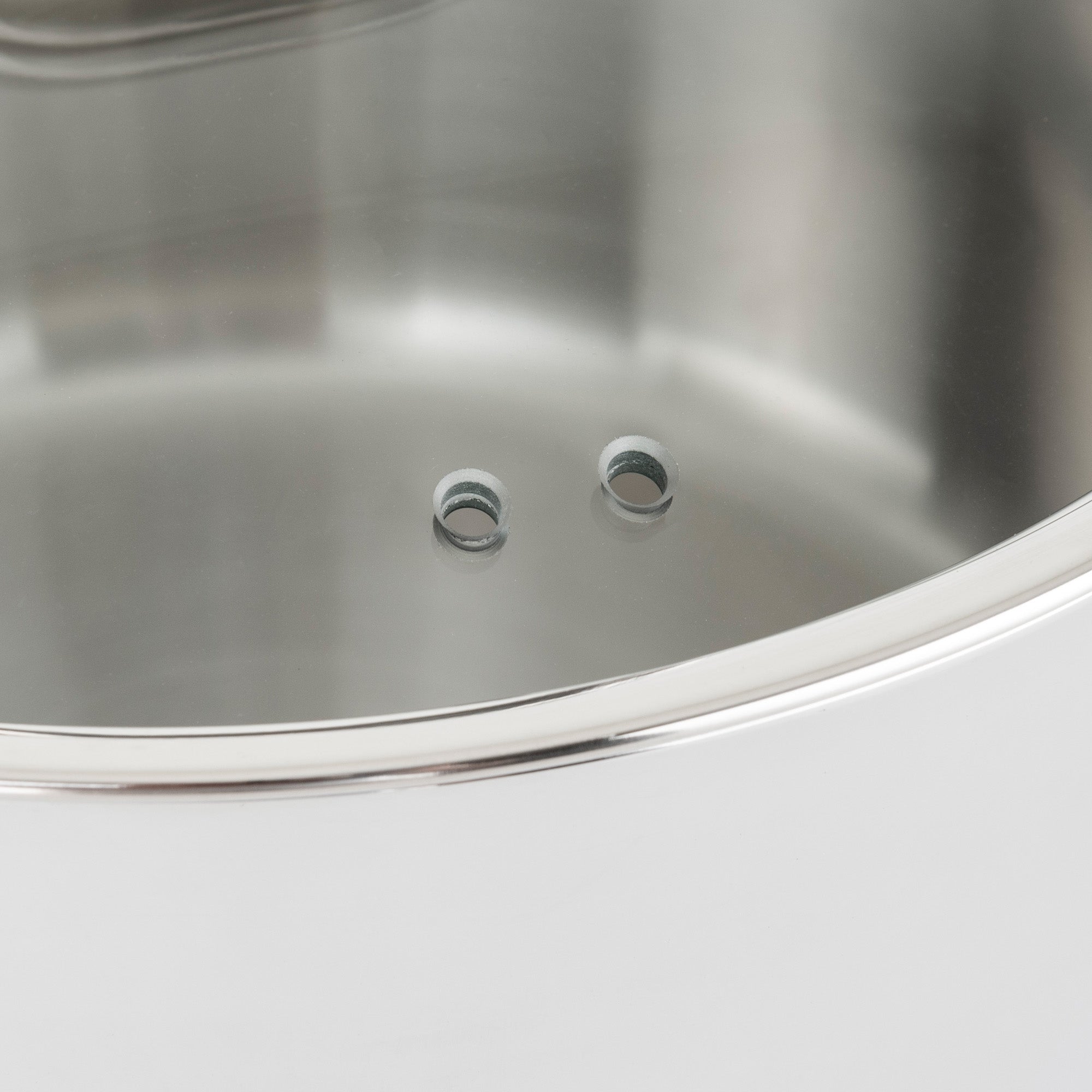 Close-up of a shiny Viking Contemporary 3-Ply Stainless Steel pot lid with two steam holes, smooth reflective surface, and thin rim. Designed for an 8-inch fry pan from the Viking Culinary Products 10-piece cookware set. Dishwasher safe.