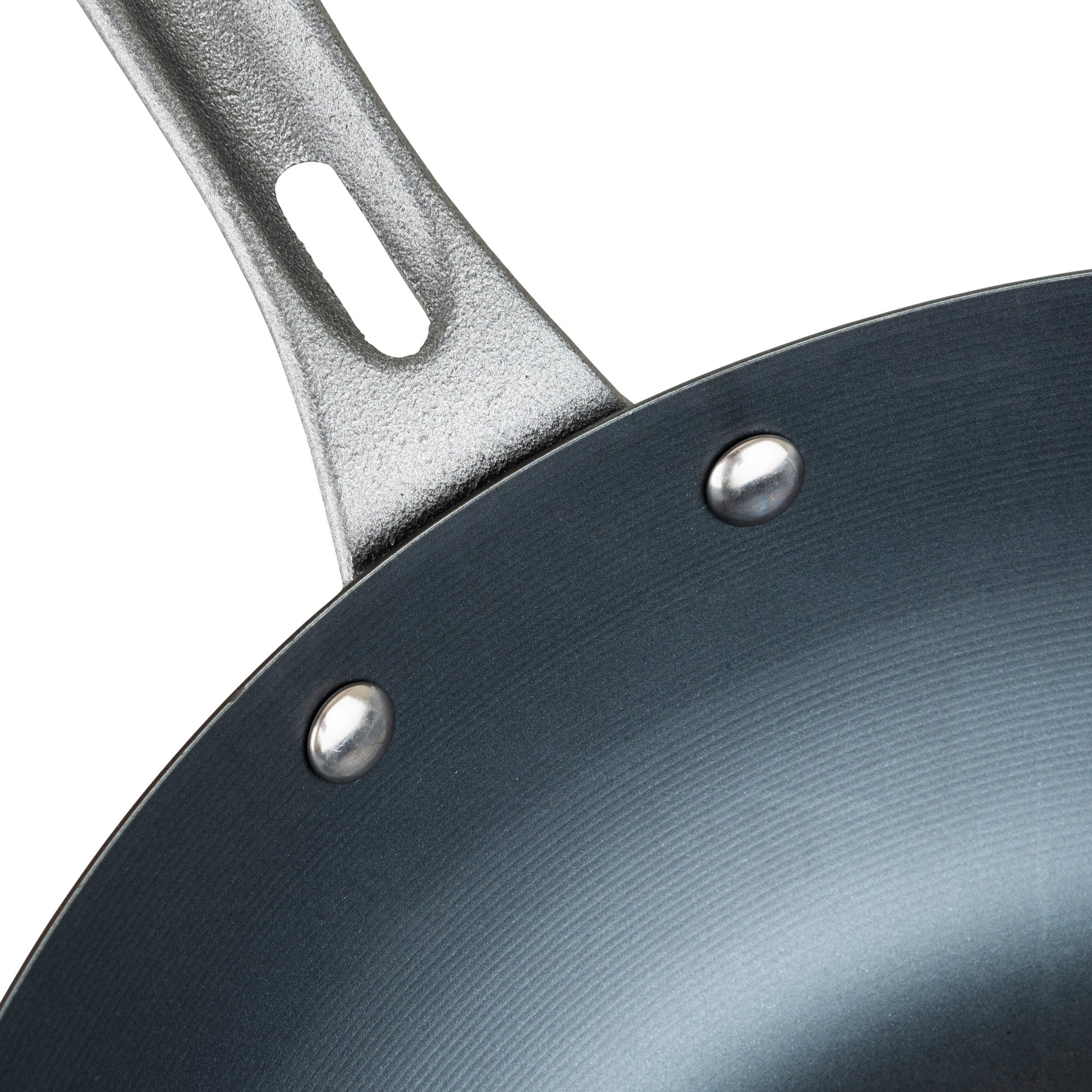 Close-up of the Viking Culinary Products Viking Blue Carbon Steel 12-Inch Wok, featuring part of its handle and rivets, with a smooth, dark pre-seasoned carbon steel nonstick interior surface.